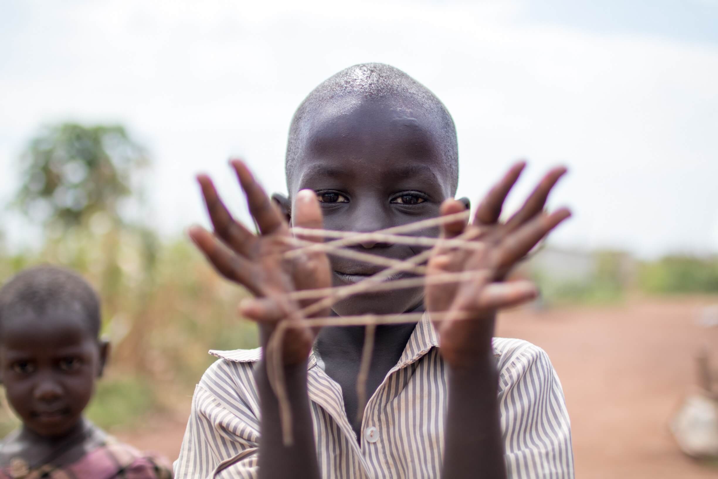 Boy Smiling While Showing Hand String Game